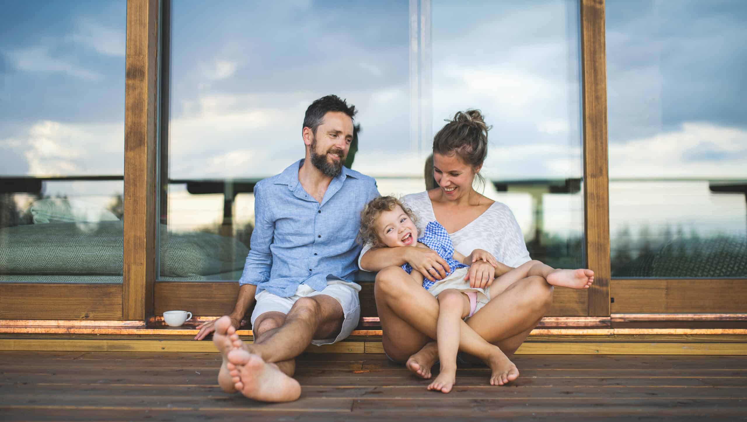 Glückliche Familie auf der Terrasse eines Holzhauses